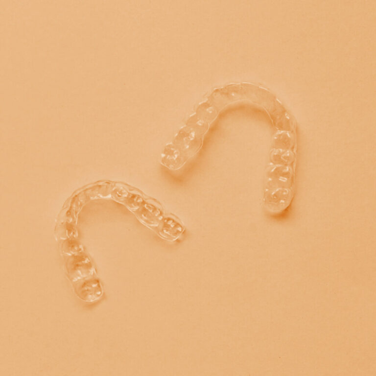 Clear aligners on an orange background